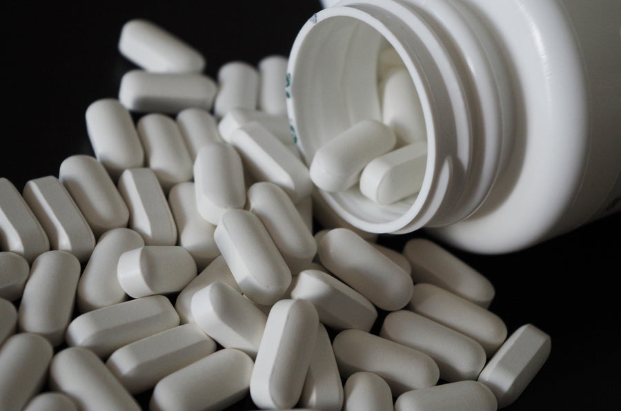 Whit pills spilling from bottle