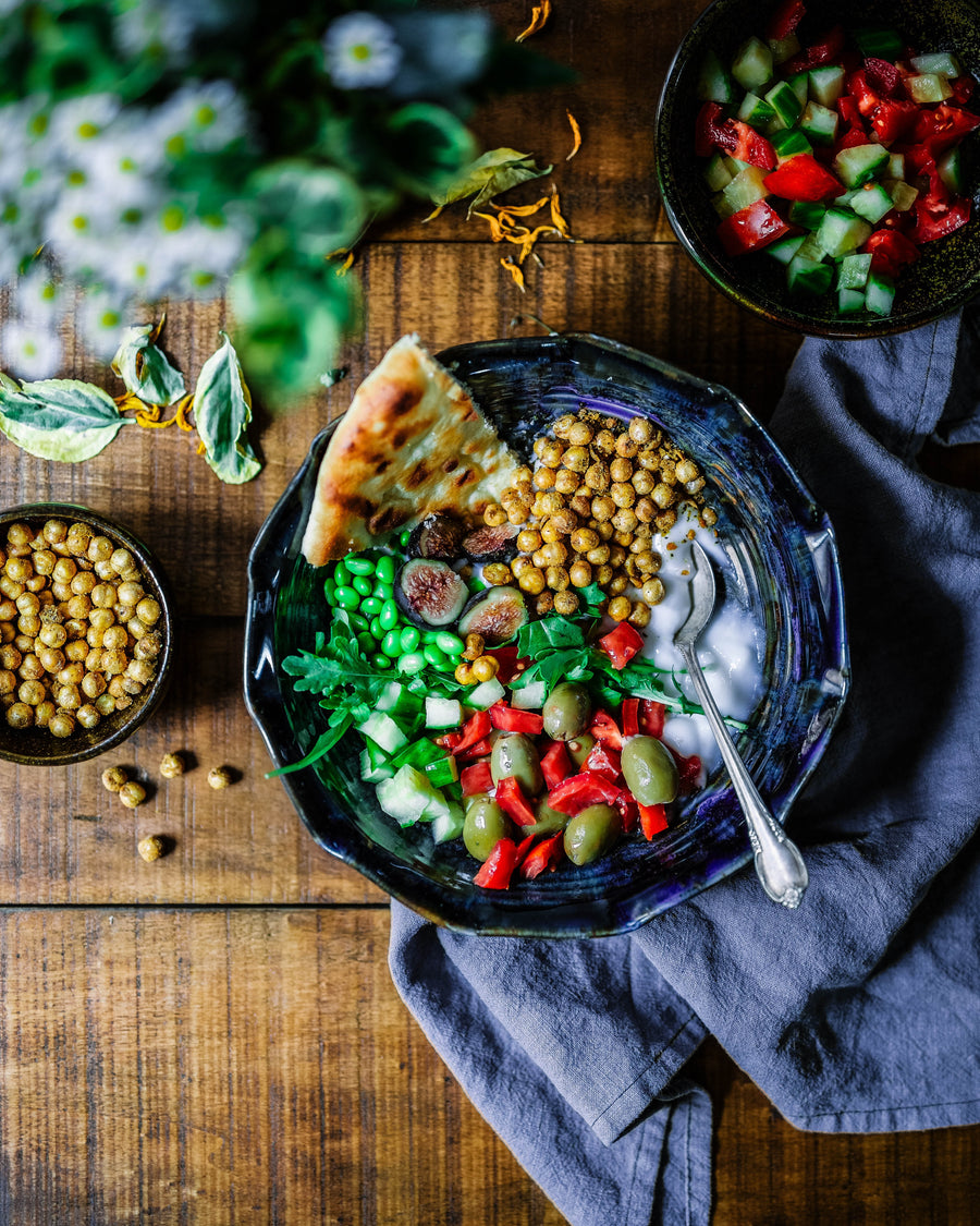 A bowl of veggies and pita bread