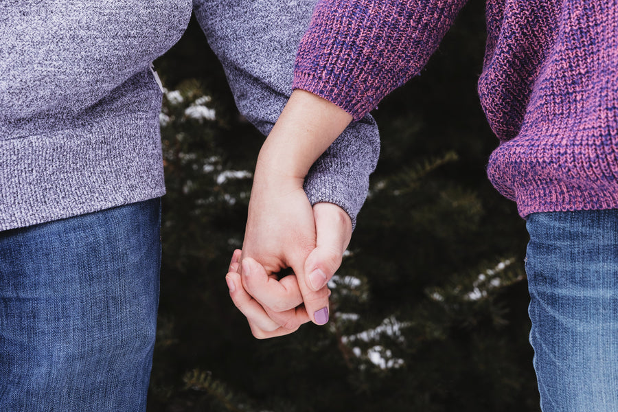 A close up of two people holding hands